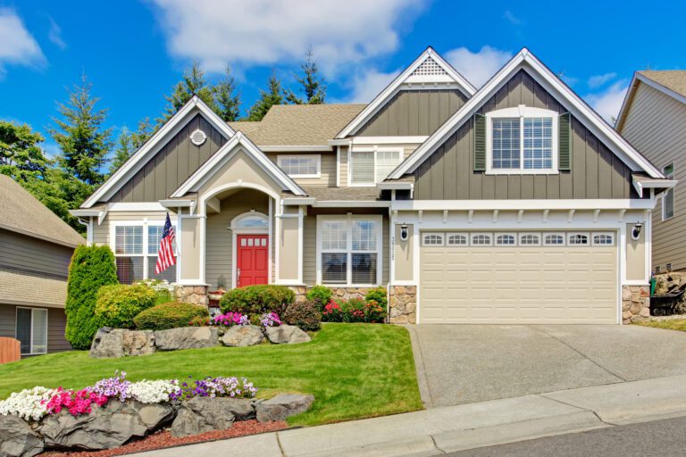 Tan beautiful home with red door nicely landscaped